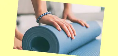 A woman folding an exercise mat.