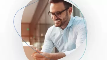 Smiling man in glasses using a tablet.