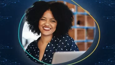 Smiling woman with curly hair using a computer.