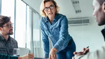 Professional woman presenting to her colleagues in a modern office setting
