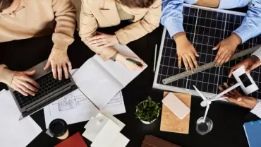 A group of girls and boys working on a desk