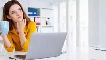 Une jeune diplômée à la recherche d’un emploi, réfléchissant à son avenir, une tasse à la main.