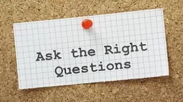 Notitie op een prikbord met de tekst 'Ask the Right Questions'.