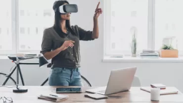 Woman using VR headset in modern office setting.