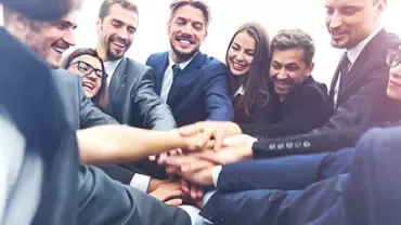 Groupe de professionnels joignant les mains en équipe.