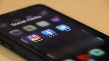 Écran de smartphone montrant des apps: Instagram, Facebook, Twitter.