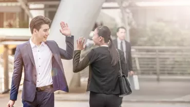 Twee zakenmensen geven elkaar een high five buiten.