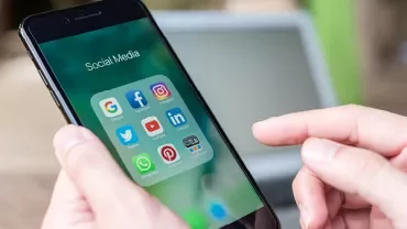 Un smartphone montrant des applications de médias sociaux dans la main d'une personne.