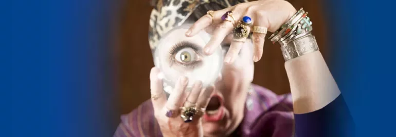 Person with rings and headscarf looking through magnifying glass, surprised expression.