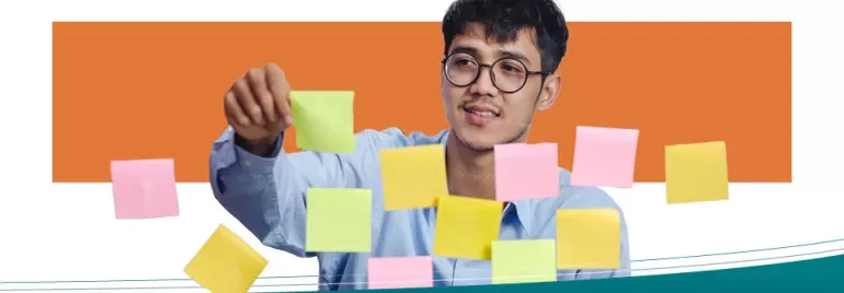A man placing sticky notes on a transparent board.