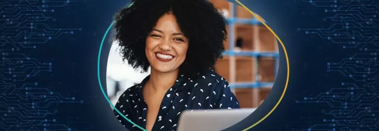 Smiling woman with curly hair using a computer.