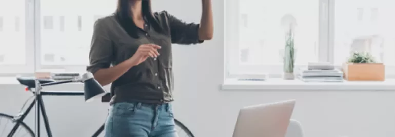 Vrouw met VR-bril in een moderne kantooromgeving.
