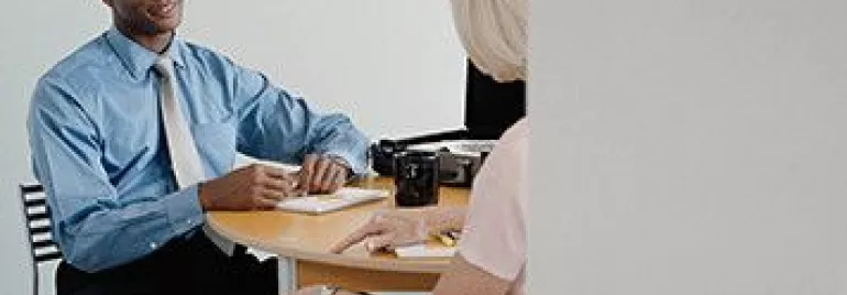 Two people having a business meeting at a table.
