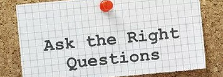 Paper pinned to cork board saying 'Ask the Right Questions'.