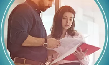 Man and woman reviewing documents in an office.