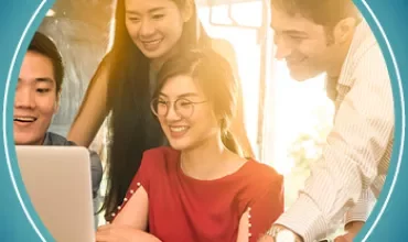 Group of people smiling and looking at a laptop.