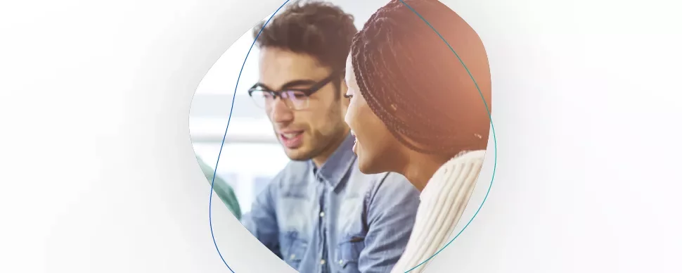 Two people having a conversation, one wearing glasses.