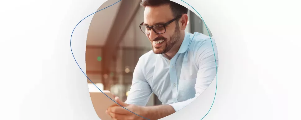 Smiling man in glasses using a tablet.