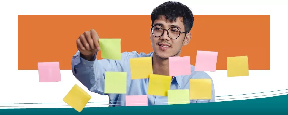 A man placing sticky notes on a transparent board.