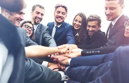Groupe de professionnels joignant les mains en équipe.